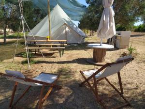 two folding chairs and a tent with a table and a table at Torre Lapillo Agricampeggio in Torre Lapillo