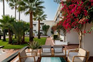 a patio with chairs and flowers and palm trees at Parador de Moj&aacute;car in Moj&aacute;car