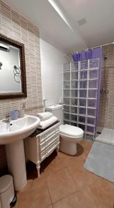 a bathroom with a sink and a toilet and a mirror at La Casa de la Acacia in Olba