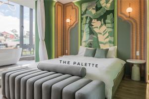 大叻的住宿－The Palette Dalat，一间卧室配有一张床和壁画墙