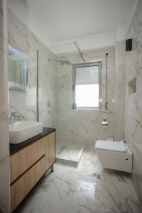 446 Luxury Apartament Center في شكودر: حمام مع حوض وحوض استحمام ومرحاض
