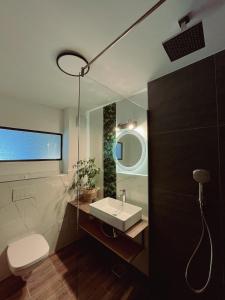 ein Bad mit einem Waschbecken und einem Spiegel in der Unterkunft Pensiunea Senin in Sovata