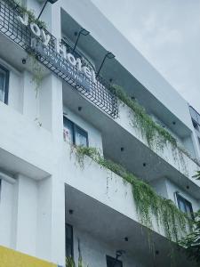 um edifício branco com plantas na lateral em Joy Hotel Phú Yên em Tuy Hoa