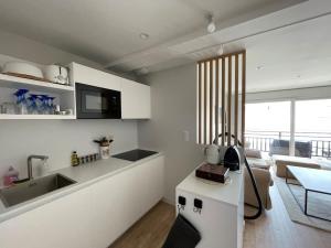 una cucina con mobili bianchi e un piano di lavoro di Le Paris Plage a Le Touquet-Paris-Plage