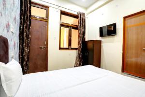 1 dormitorio con cama, puerta y TV en OYO Spot On A 1 Galaxy, en Kānpur