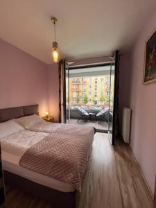 a bedroom with a bed and a view of a balcony at Mona Sun Apart in Gdynia