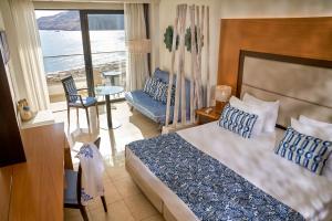 Habitación de hotel con cama y vistas al océano en Lindos Bay Hotel en vlicha