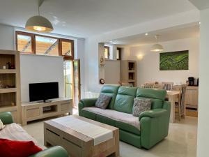 a living room with a green couch and a kitchen at Stunning 3 bedroom Villa in Moneasa in Moneasa