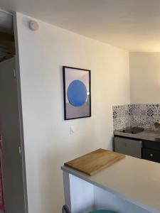 uma cozinha com um balcão com um círculo azul na parede em Le studio de l'artiste. em Arles