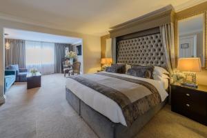 A bed or beds in a room at Killarney Oaks Hotel