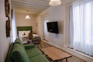 een woonkamer met een bank, een tafel en een bed bij 4U Suites in Granada