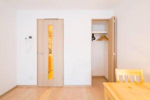 una puerta en una habitación con una mesa y una habitación con una puerta en ID Ohmori20 en Tokio