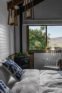 1 dormitorio con cama, ventana y silla en Live in the woods, en Mikhmannim