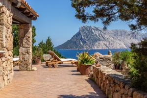 a patio with a view of the water and a mountain at Villa Rubia - Belocations in Monte Petrosu
