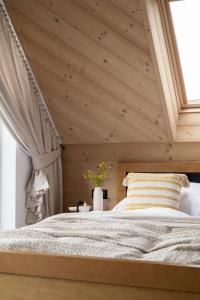 a bedroom with a large bed with a wooden ceiling at Rychlinowe Domki in Poronin