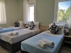 ein Schlafzimmer mit 3 Betten und Handtüchern darauf in der Unterkunft Iris Studios Chios in Karfás