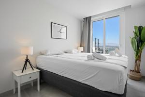Un dormitorio blanco con una cama grande y una ventana. en Stunning Apt in Mijas by Costarentals - Ref 230, en La Cala de Mijas