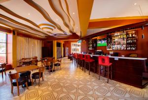 a restaurant with a bar with red chairs and tables at Mount Royal Villa in Iringa