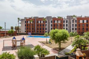 an apartment complex with a playground and a swimming pool at Cubelles mar in Cubelles