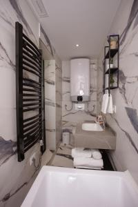 a bathroom with a white tub and a sink at 446 Tiny House Shirokë in Široka