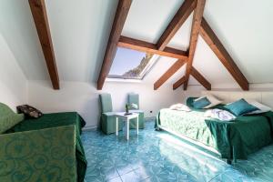 a attic room with two beds and a table at Hotel Villa Annalara charme and relax in Amalfi