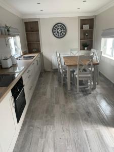 a kitchen with a table and a table and chairs at Farsnagh Cottage in Newport Trench