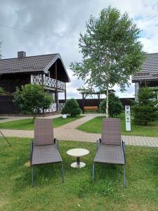 two chairs and a table in front of a house at Ostrivky in Svityazʼ