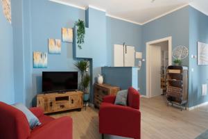 波隆那的住宿－CASA PETRONIO APARTMENTS BOLOGNA CENTER，客厅配有2把红色椅子和电视