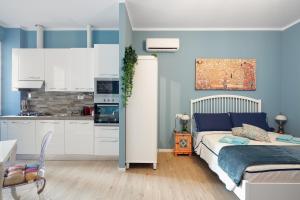 a bedroom with a bed and a kitchen at CASA PETRONIO APARTMENTS BOLOGNA CENTER in Bologna