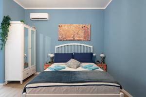 sypialnia z dużym łóżkiem z niebieskimi ścianami w obiekcie CASA PETRONIO APARTMENTS BOLOGNA CENTER w Bolonii