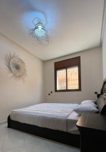 a bedroom with a bed and two chandeliers on the ceiling at Appartement au coeur d'Aourir in Aourir