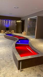 a hotel lobby with a red and blue pool at Hotel Intermonti in Livigno