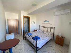 a bedroom with a bed and a table in it at Lecce Rooms in Castro di Lecce +26 photos