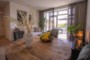 - un salon avec une table en bois et un bol de fruits dans l'établissement Appartement 't Groentje 9A Domburg DO43, à Domburg