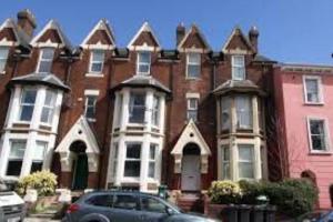 a large red brick building with a car parked in front at St Davids Central Apartment in Exeter