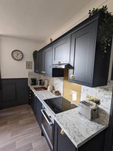 een keuken met zwarte kasten en een aanrecht bij St Davids Central Apartment in Exeter