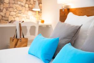 Una cama con almohadas azules y blancas. en Hostal Boutique Casa del Mar Altea, en Altea