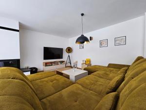 a living room with a couch and a tv at BudinSKI Apartmány & Wellness in Liptovský Mikuláš