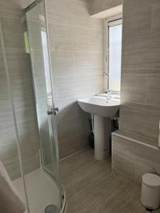 a bathroom with a glass shower and a sink at 3 bedrooms flat Crystal Palace in London