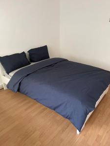 ein Bett mit blauer Bettwäsche und Kissen in einem Schlafzimmer in der Unterkunft 3 bedrooms flat Crystal Palace in London
