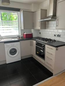 a kitchen with a stove and a washing machine at 3 bedrooms flat Crystal Palace in London