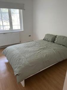 Bett in einem weißen Schlafzimmer mit Fenster in der Unterkunft 3 bedrooms flat Crystal Palace in London
