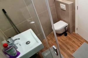 uma casa de banho com um lavatório branco e um WC. em Amar 3 em Zemun