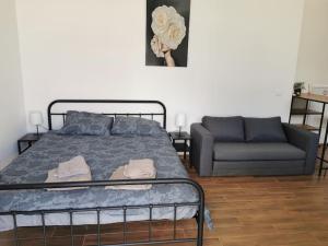 um quarto com uma cama e um sofá em Amar 3 em Zemun