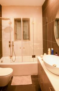 ein Bad mit einer Badewanne, einem Waschbecken und einer Dusche in der Unterkunft Hapalmah One, Jerusalem, Dira 2 in Jerusalem
