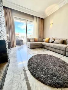 a living room with a couch and a rug at Appartement face à la mer et à 10min du centre-ville in Casablanca