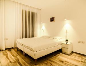 ein weißes Schlafzimmer mit einem Bett und einem Fenster in der Unterkunft Hapalmah One, Jerusalem, Dira 2 in Jerusalem