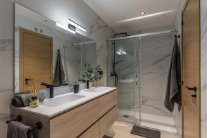 La salle de bains est pourvue de 2 lavabos et d'une douche en verre. dans l'établissement TOTEC VENTURES, à Madrid