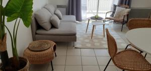 sala de estar con sofá, sillas y mesa en L'Appart' - ADRIAE Home, en LʼAiguillon-sur-Mer