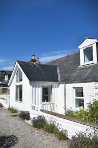 a white house with a black roof at Dram Cottage, Findhorn Bay in Forres